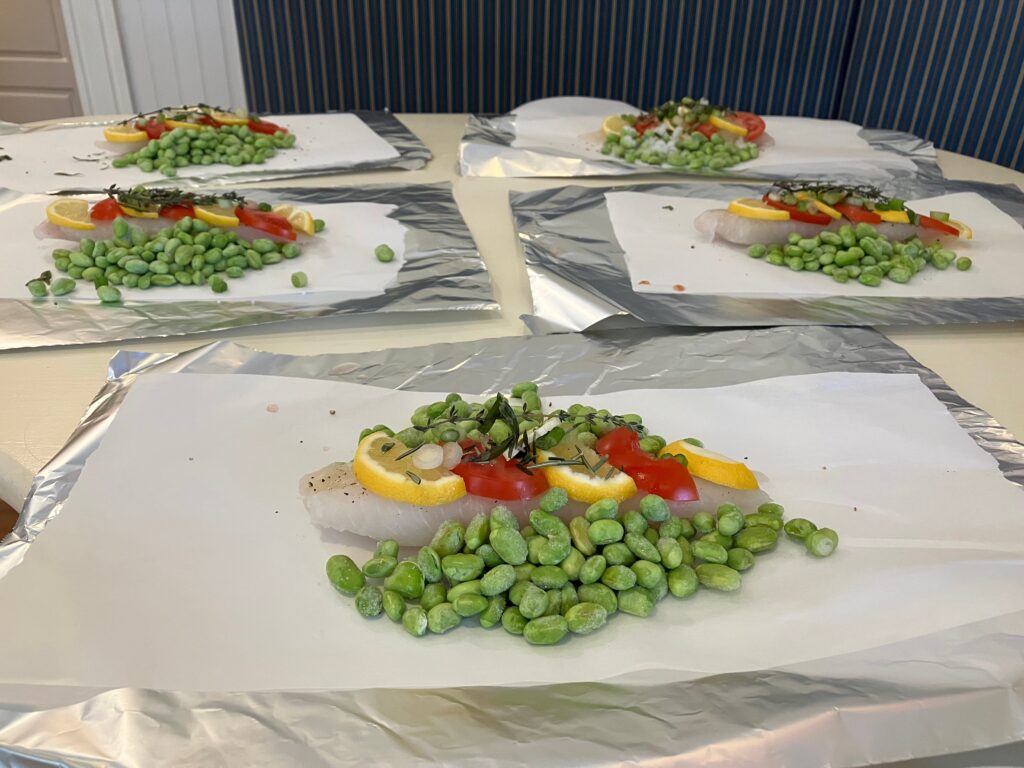 fish and vegetables laid out on parchment and aluminum foil